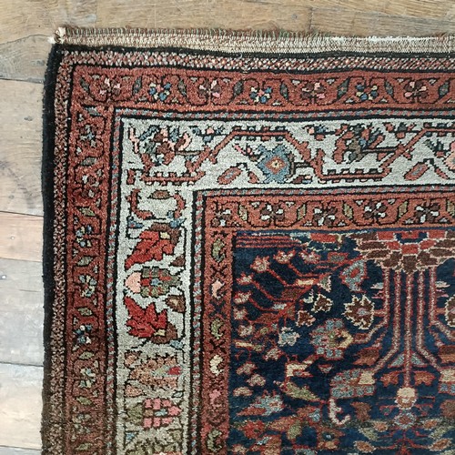 1287 - A Persian red ground rug, 200 x 112 cm