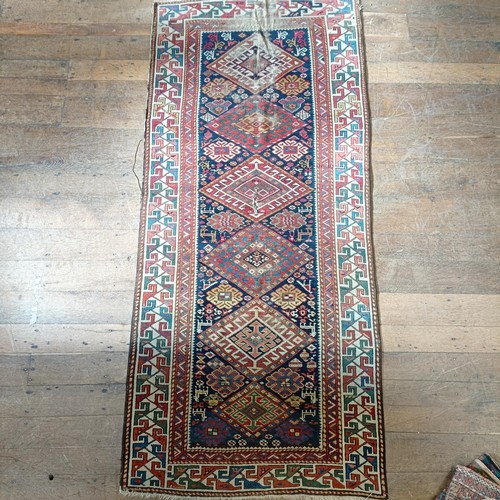 1288 - A Caucasian red ground rug, 245 x 108 cm