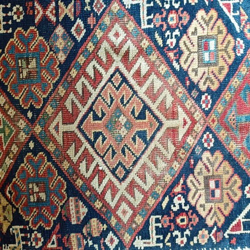 1288 - A Caucasian red ground rug, 245 x 108 cm