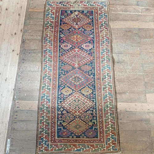 1288 - A Caucasian red ground rug, 245 x 108 cm