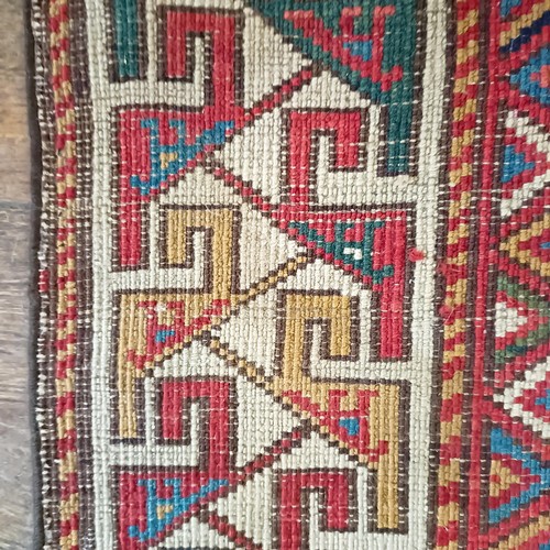 1288 - A Caucasian red ground rug, 245 x 108 cm