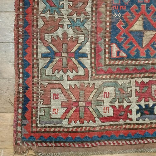 1303 - A Caucasian red ground rug, 216 x 125 cm