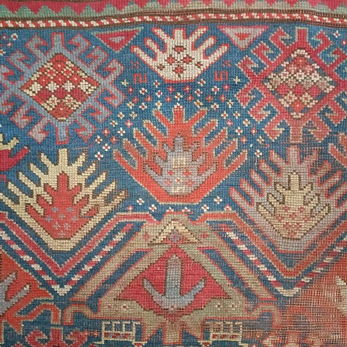 1303 - A Caucasian red ground rug, 216 x 125 cm