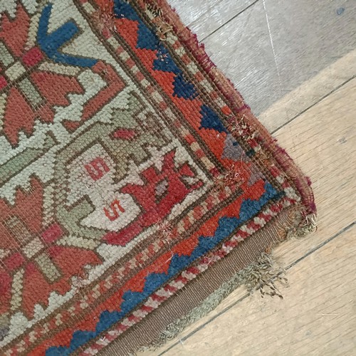 1303 - A Caucasian red ground rug, 216 x 125 cm