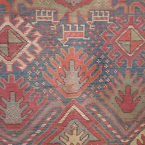 1303 - A Caucasian red ground rug, 216 x 125 cm