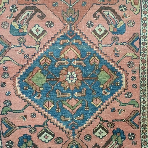 1309 - A Persian salmon pink ground rug, 202 x 98 cm