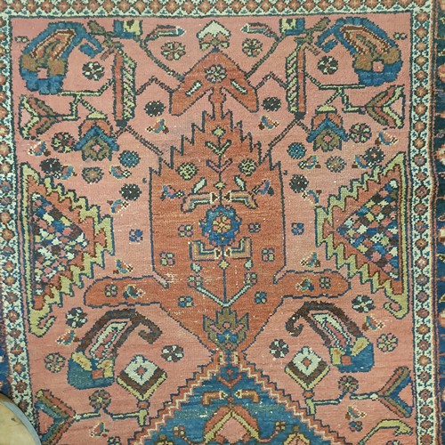 1309 - A Persian salmon pink ground rug, 202 x 98 cm