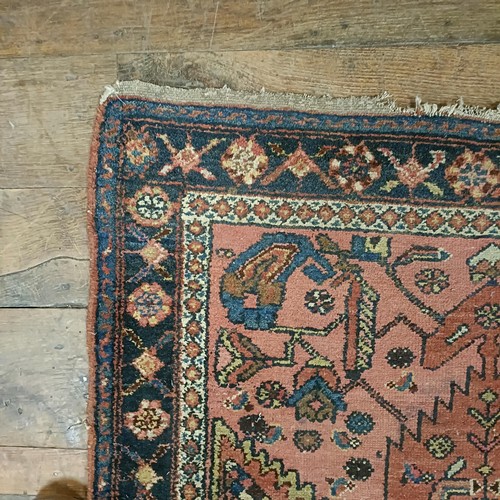 1309 - A Persian salmon pink ground rug, 202 x 98 cm