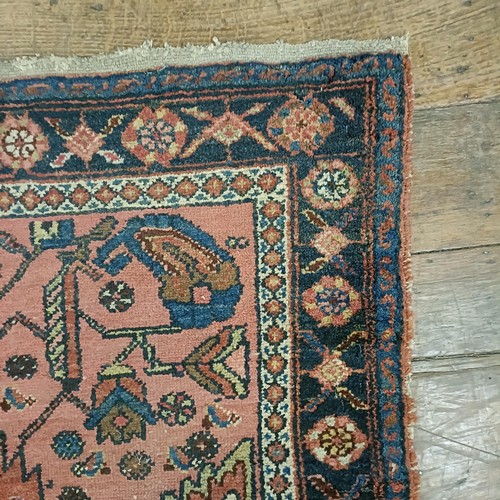 1309 - A Persian salmon pink ground rug, 202 x 98 cm