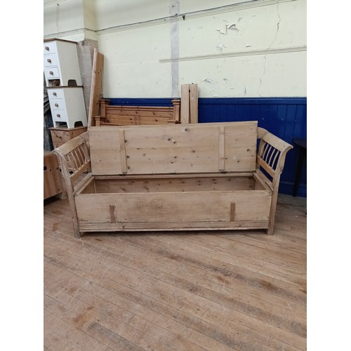 1383 - A stripped pine day bed, with a hinged seat, 210 cm wide