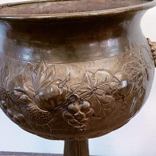 1302 - An embossed brass jardinière, on stand, 107 cm high