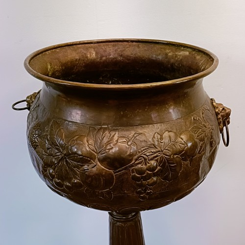 1302 - An embossed brass jardinière, on stand, 107 cm high