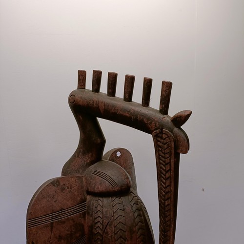 1306 - A large African carved wooden figure of a bird, 152 cm high