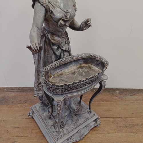 1298 - A large spelter figure of a lady in front of a table, on a square base, 100 cm high