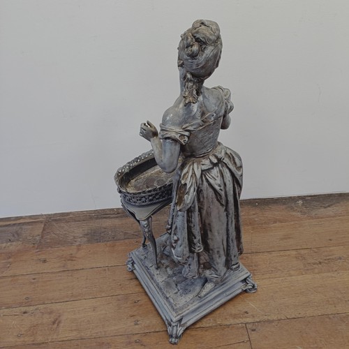 1298 - A large spelter figure of a lady in front of a table, on a square base, 100 cm high