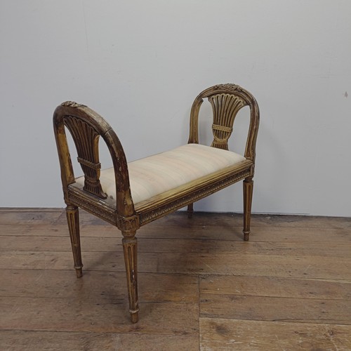 1283 - An early 20th century gilt window seat, with pierced ends, on reeded tapering legs, 86 cm wide