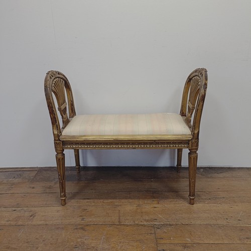 1283 - An early 20th century gilt window seat, with pierced ends, on reeded tapering legs, 86 cm wide