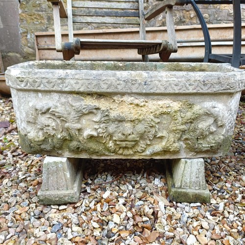 1444 - A composite stone rectangular planter, with carved lion decoration, on composite stone stands...