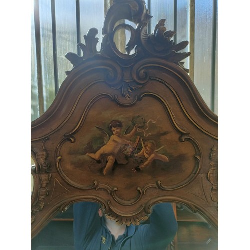 1375 - A large and impressive Continental walnut mirror, the cornice painted cherubs, carved foliate forms,... 