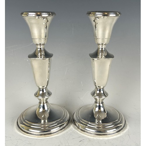 1801 - A pair of sterling silver candlesticks, 19 cm high and a silver coloured metal salt and pepper, in a... 