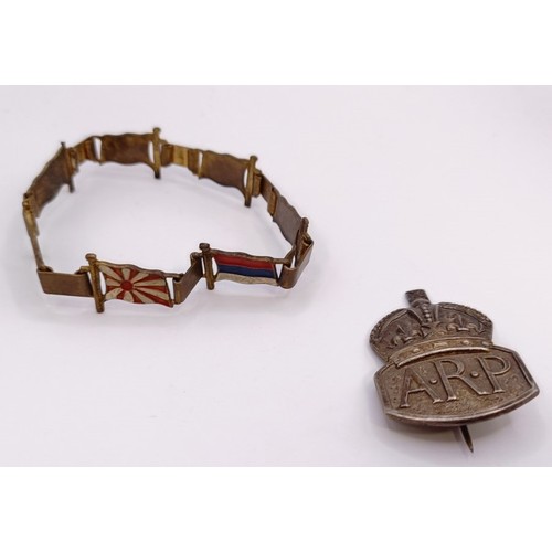 591 - A gilt metal and enamel novelty bracelet, decorated flags of World War II Allies, and a ARP badge (2... 