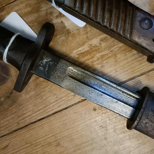 500 - A 1907 pattern bayonet, in a leather scabbard, and two other bayonets with scabbards (3)