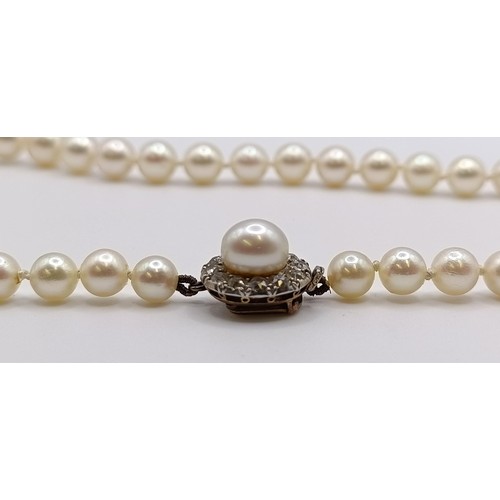 1605 - A cultured pearl necklace, with a diamond clasp, in a vintage jewellery box