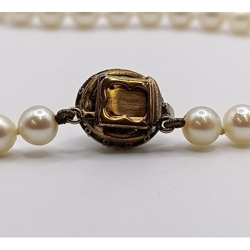 1605 - A cultured pearl necklace, with a diamond clasp, in a vintage jewellery box