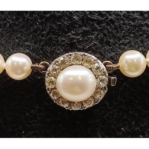 1605 - A cultured pearl necklace, with a diamond clasp, in a vintage jewellery box