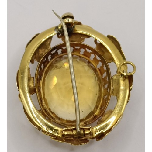 1656 - An early 20th century yellow metal and yellow stone oval brooch, 40 mm wide approx.