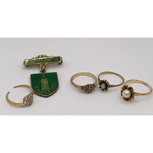 1689 - A 9ct gold and diamond cluster ring, ring size K, two other rings and a badge (4)