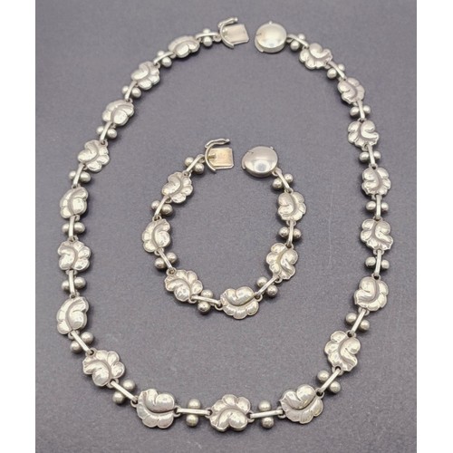 1721 - A Georg Jensen silver necklace, decorated floral forms, and a matching bracelet, 66.4 g