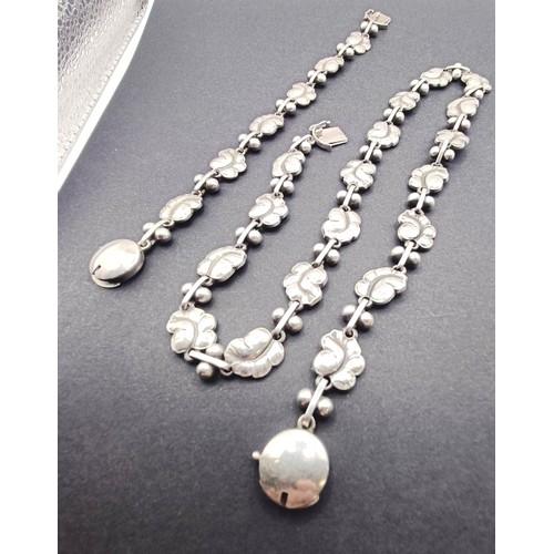 1721 - A Georg Jensen silver necklace, decorated floral forms, and a matching bracelet, 66.4 g