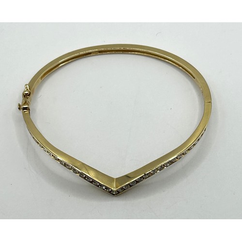 1752 - An 18ct gold and diamond set wishbone hinged bangle