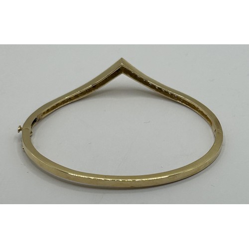 1752 - An 18ct gold and diamond set wishbone hinged bangle