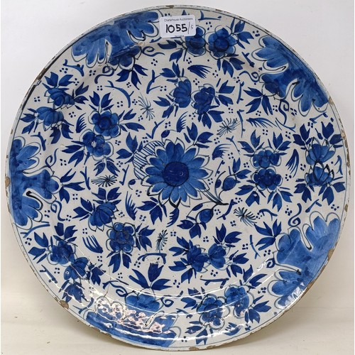 1055 - A Dutch blue and white Delft plate, 31 cm diameter, and four other Delft plates (5)