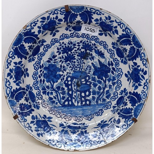 1055 - A Dutch blue and white Delft plate, 31 cm diameter, and four other Delft plates (5)