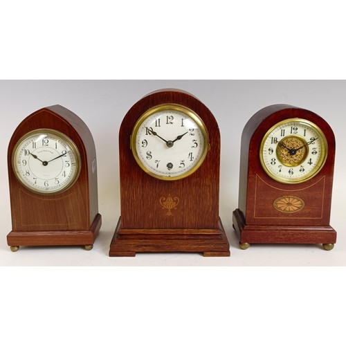 1214 - An Edwardian mantel clock, in an inlaid mahogany case, 21.5 cm high, and two others similar (3)