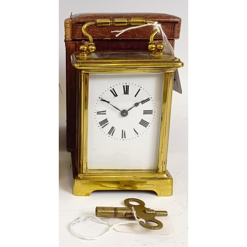 1217 - A carriage clock, with an enamel dial, in a brass case, 15 cm high, in a leather travelling case