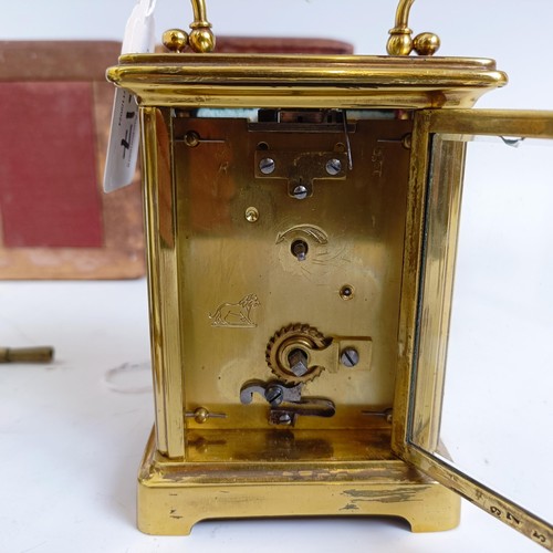 1217 - A carriage clock, with an enamel dial, in a brass case, 15 cm high, in a leather travelling case