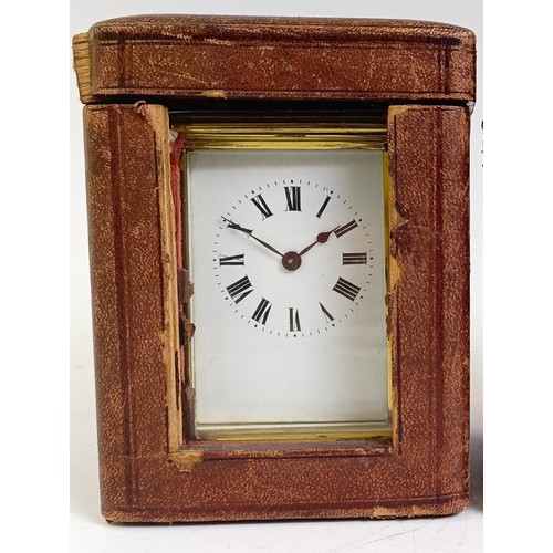 1217 - A carriage clock, with an enamel dial, in a brass case, 15 cm high, in a leather travelling case