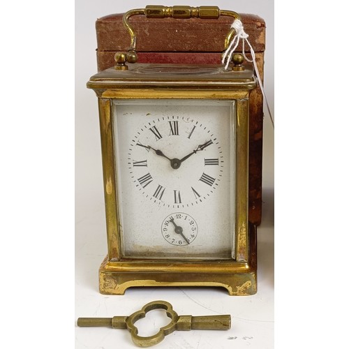 1218 - A carriage clock, with alarum, the enamel dial in a brass case, 15 cm high, in a leather travelling ... 