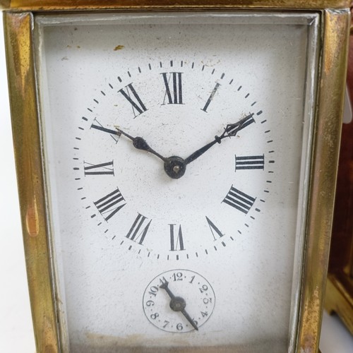 1218 - A carriage clock, with alarum, the enamel dial in a brass case, 15 cm high, in a leather travelling ... 