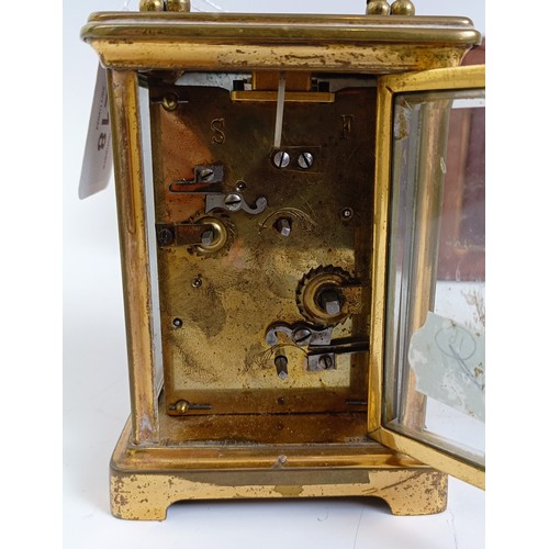 1218 - A carriage clock, with alarum, the enamel dial in a brass case, 15 cm high, in a leather travelling ... 