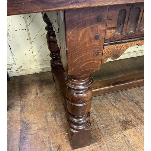 1259 - A large 18th century style oak refectory dining table, with turned legs, united by a stretcher, the ... 