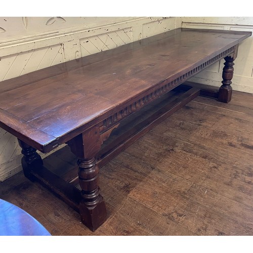 1259 - A large 18th century style oak refectory dining table, with turned legs, united by a stretcher, the ... 