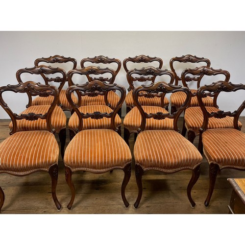 1280 - A set of twelve Victorian rosewood balloon back dining chairs, with carved top and central rails, pa... 