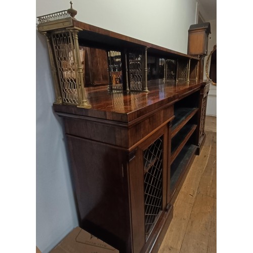 1274 - A late Regency rosewood inverted breakfront bookcase, with a mirrored superstructure raised on metal... 