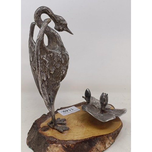 1149 - A figure of a crane with lily pads, on an associated wood base, and another similar group (2)