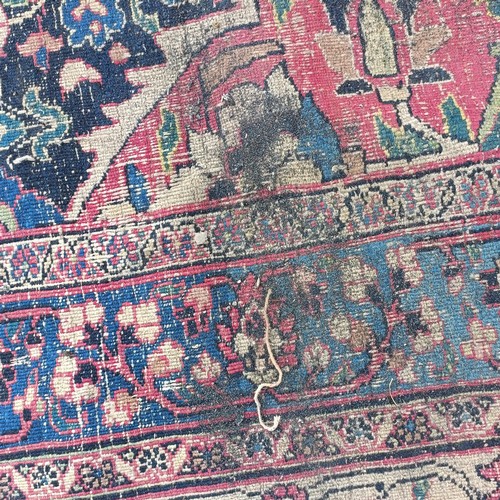 1281 - A large Persian style carpet, heavily worn, 477 cm x 326 cm